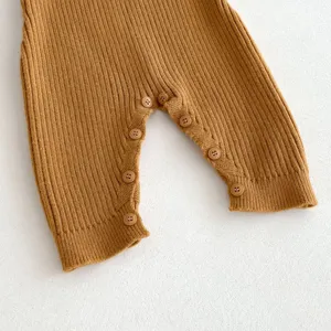 Knit baby romper button detail close up view, soft wool fabric texture for infant boys and girls.