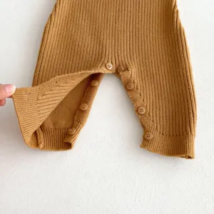 Close-up detail showing infant knitted romper buttons and soft ribbed fabric texture for autumn.