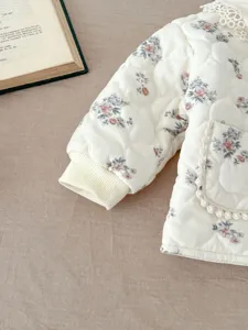 Detailed shot of baby quilted jacket with floral print, lace collar and ribbed cuffs.