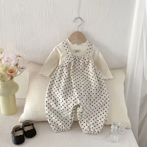 Detailansicht von süßem Baby Mädchen Pünktchen Latzhose und Langarmshirt Set, gemütlich.