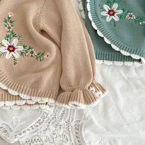 Baby girl knit cardigan with cute floral embroidery and ruffled hem. Soft cotton yarn top.