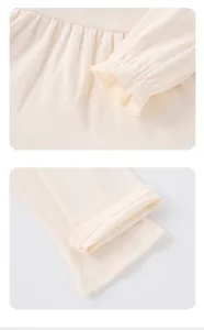 Close-up detail of girls ribbed fabric clothing featuring delicate ruffled cuffs and fine stitching.
