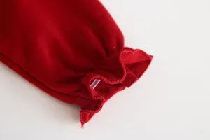 Dettaglio manica abito neonata rosso, grazioso design polsino con volant, tessuto.