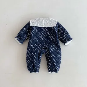 Detailed view of baby winter quilted romper in navy blue with white polka dots and lace collar.