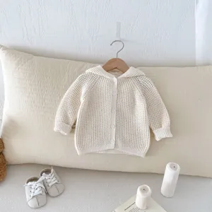 Vue rapprochée du cardigan à capuche en tricot pour bébé, texture douce, détail.