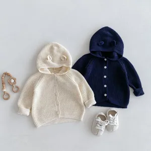 Joli gilet en tricot pour bébé avec capuche et oreilles d'ours, pull d'automne style neutre.