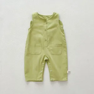 Close-up detail of infant baby light green sleeveless romper featuring front buttons and pockets.