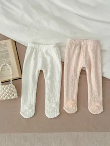 Detailed flat lay view of cute fleece-lined baby footed leggings with floral ankle cuffs.