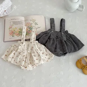 Detailed view of cute infant corduroy strap rompers in floral beige and dark grey styles.