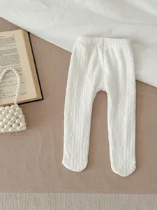Close-up of white textured baby footed leggings showing soft knit fabric and cozy winter design.