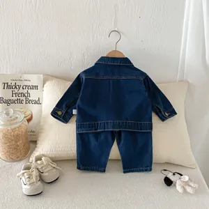 Vista dettagliata del set di giacca e pantaloni in denim esposto su un comodo cuscino.