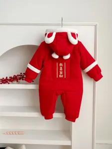Detailed shot of red baby winter romper with plush hood, rabbit ears, and festive text embroidery.