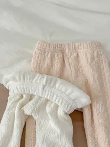 Detailed view of soft winter fleece-lined baby tights in pink and white with cute cable knit texture.