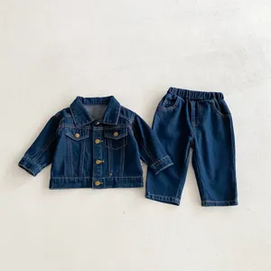Vista dettagliata del set giacca e pantaloni in jeans per bambini, tessuto morbido, bottoni e cuciture.