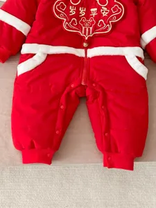 Red baby winter jumpsuit with white plush trim and festive embroidery, warm infant crawler.