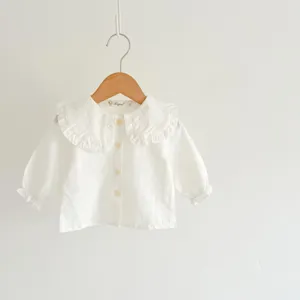 Close-up detail of a white baby girl long-sleeve blouse featuring a cute ruffled collar.