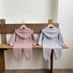 Detalle de mameluco tejido para bebé, material de lana suave con capucha, ropa cómoda para infantes.