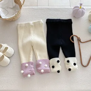 Strickleggings für Babys Detailansicht mit niedlichen Bommeln, kuschelige Hosen.