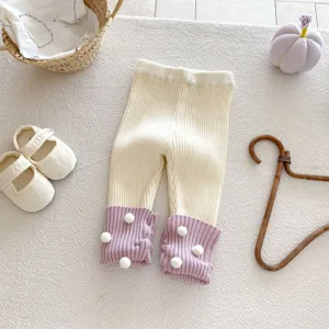 Kleinkind Strick-Leggings Detailansicht mit niedlichen Bommeln und gerippten Bündchen.