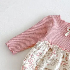Charming baby girl long sleeve romper detail, pink waffle knit top and floral skirt.