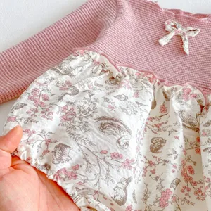 Infant baby girl long sleeve romper detail, pink waffle knit top and cute floral print bottom.