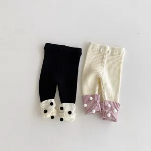 Kleinkind Strickleggings Detail, gemütliche Ripphosen für Babys mit süßen Bommelbündchen, weich.