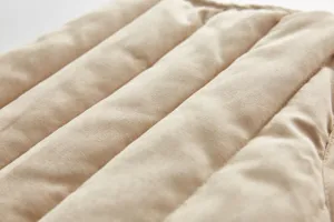 Close-up detail of children khaki quilted vest fabric, soft texture and windproof design.