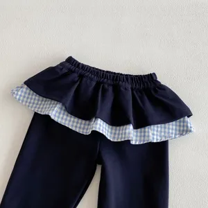 Pantaloni autunnali da bambina con vita a volant e orlo gonna a quadri blu e bianchi stile.