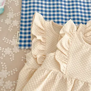 Baby jurk detail opname, close-up van de textuur van de beige romper met volants.