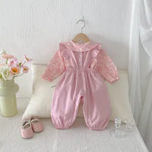 Detailansicht eines niedlichen rosa Stramplers und Blumenblusen-Sets für kleine Babys.