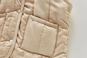 Detailed view of children quilted vest pocket and snap button, autumn winter daily wear.