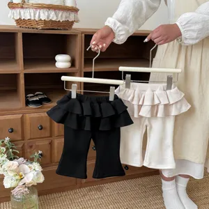 Close-up detail of toddler girls ruffle flare pants, waffle fabric and skirt design.