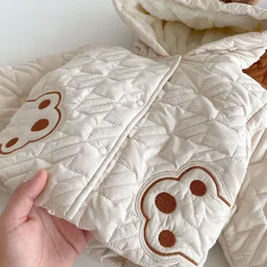 Baby winterjas detail, gevoerde capuchon gewatteerd ontwerp met schattig berenborduurwerk.