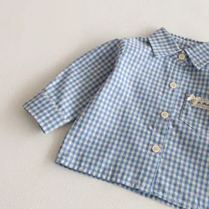 Primo piano dettaglio della camicia a quadri vichy blu e bianca a maniche lunghe con tasca.