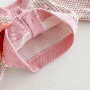 Pink checkered baby cardigan detail view showing inner striped lining and soft fabric.