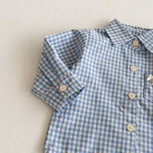 Vista dettagliata della camicia a maniche lunghe a quadri blu e bianchi per bambini con bottoni.
