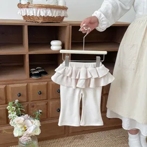 Close-up showcase of toddler girls waffle knit flared pants featuring layered ruffle skirt.