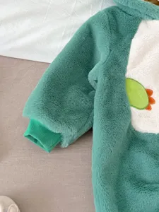 Vista dettagliata della tutina in pile per neonato con cappuccio di dinosauro caldo.