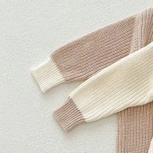 Nahaufnahme Strickdetail des Babypullovers, Kontrastfarbiger Ärmel, weicher Stoff.