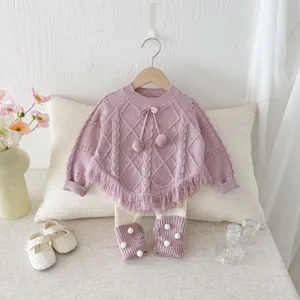 Detailed view of baby girl knitted sweater set with fringe, purple top and cute accessories.