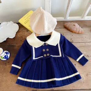 Detailed view of toddler girls navy style knit sweater dress with pleated skirt and beret.