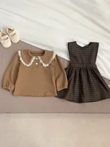 Detailed shot of baby toddler girl long sleeve top and plaid dress set, cute spring outfit.
