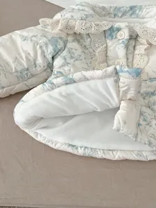 Close-up detail of infant winter padded jacket with fleece lining and delicate lace collar.