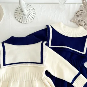 Detail view of girls sailor knit dress, long sleeve pleated sweater dress in contrast colors.
