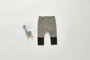 Infant black and white striped cotton long pants detailed view and flat layout style.