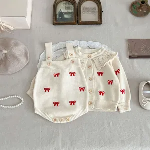 Baby knit cardigan and romper set detailed flat lay showing cute red bow embroidery.