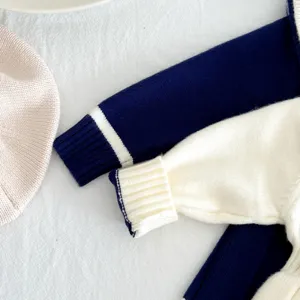 Detailed shot of baby girl knit sweater sleeve with navy stripe and cute pink beret prop.