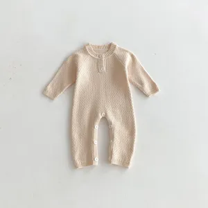 Cozy beige knitted baby romper with raglan sleeves and cute button closure for infants.