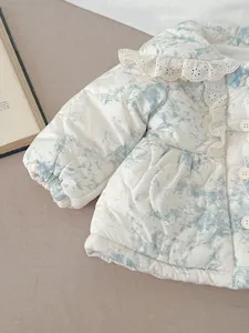 Detail view of a cozy baby winter quilted jacket featuring a cute lace collar and blue dye.