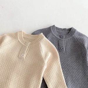 Cute baby knitted romper detail, raglan sleeves, button front, cozy autumn infant clothing.